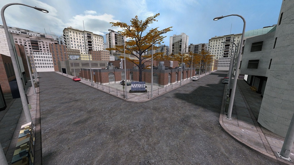 Front view of the branch bank, empty streets with scant parked cars, tall buildings in the background.